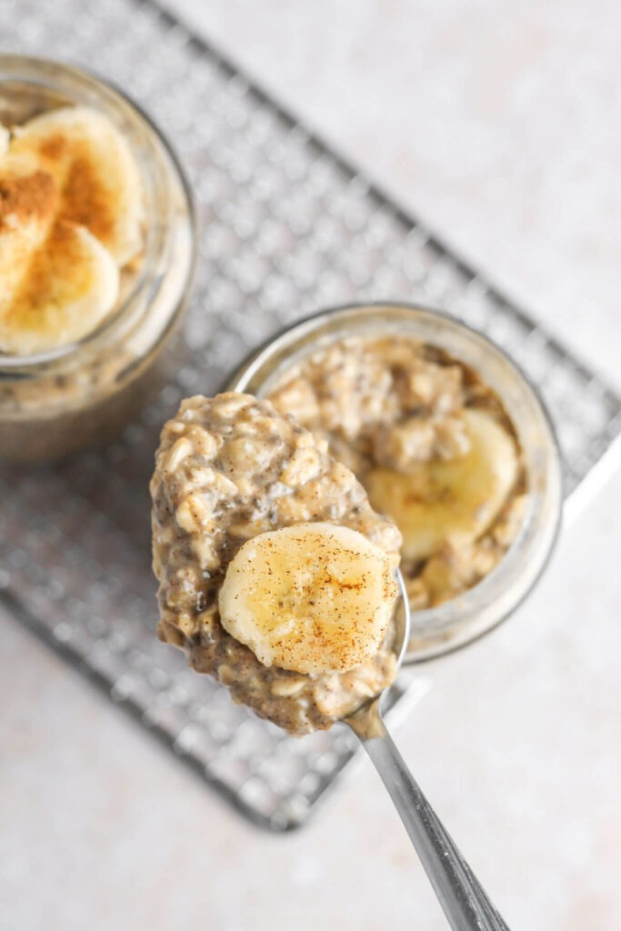 Spoonful of Banana cinnamon overnight oats topped a banana sprinkled with cinnamon