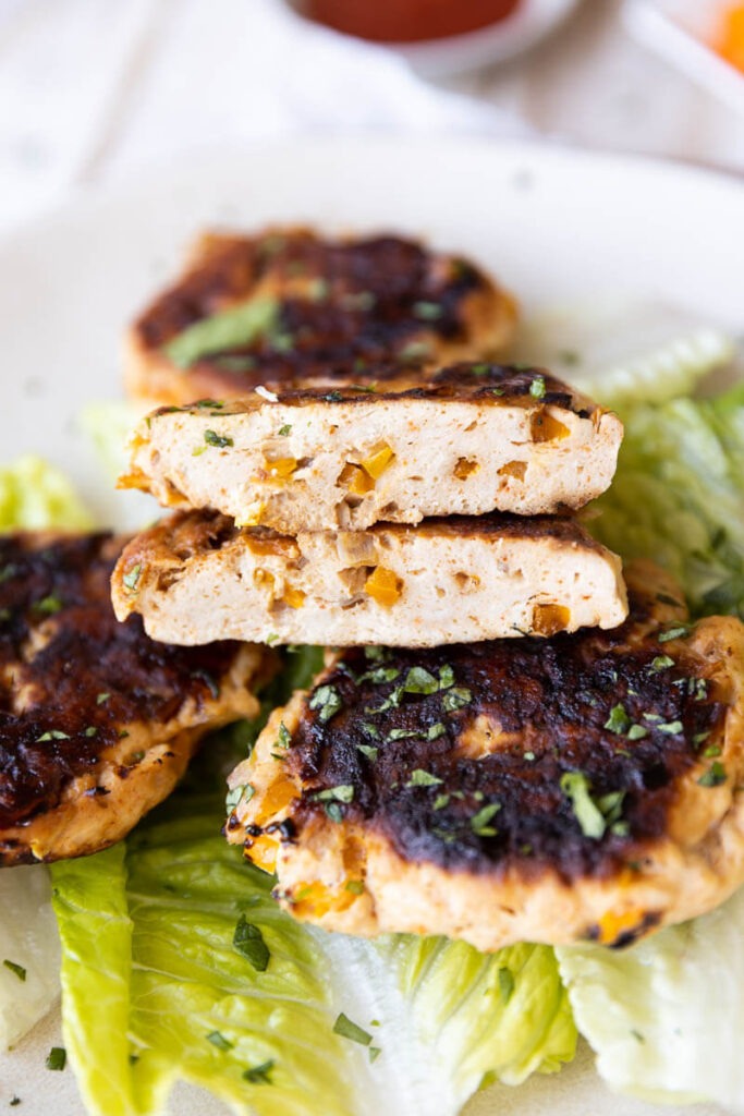 Cooked chicken burgers with bell pepper and onion chunks inside