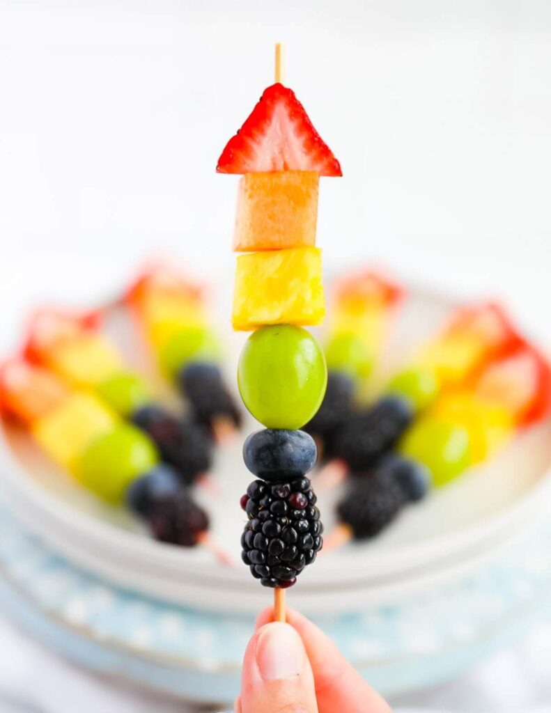 Strawberry triangle, cantaloupe cube, pineapple cube, green grape, blueberry, blackberry on skewer