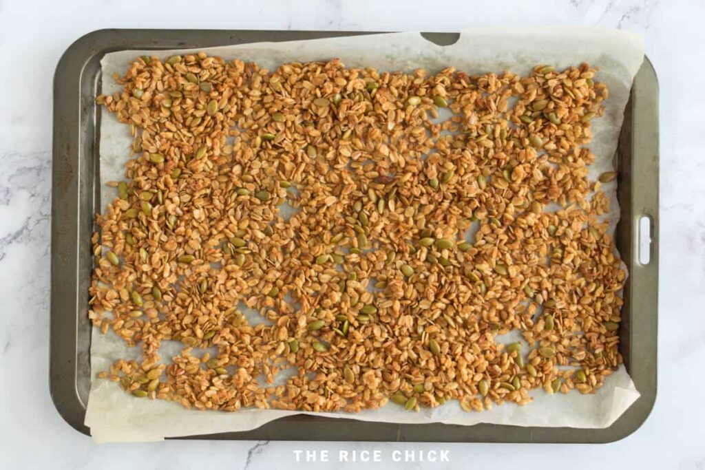 Baking sheet with puffed rice granola on parchment paper