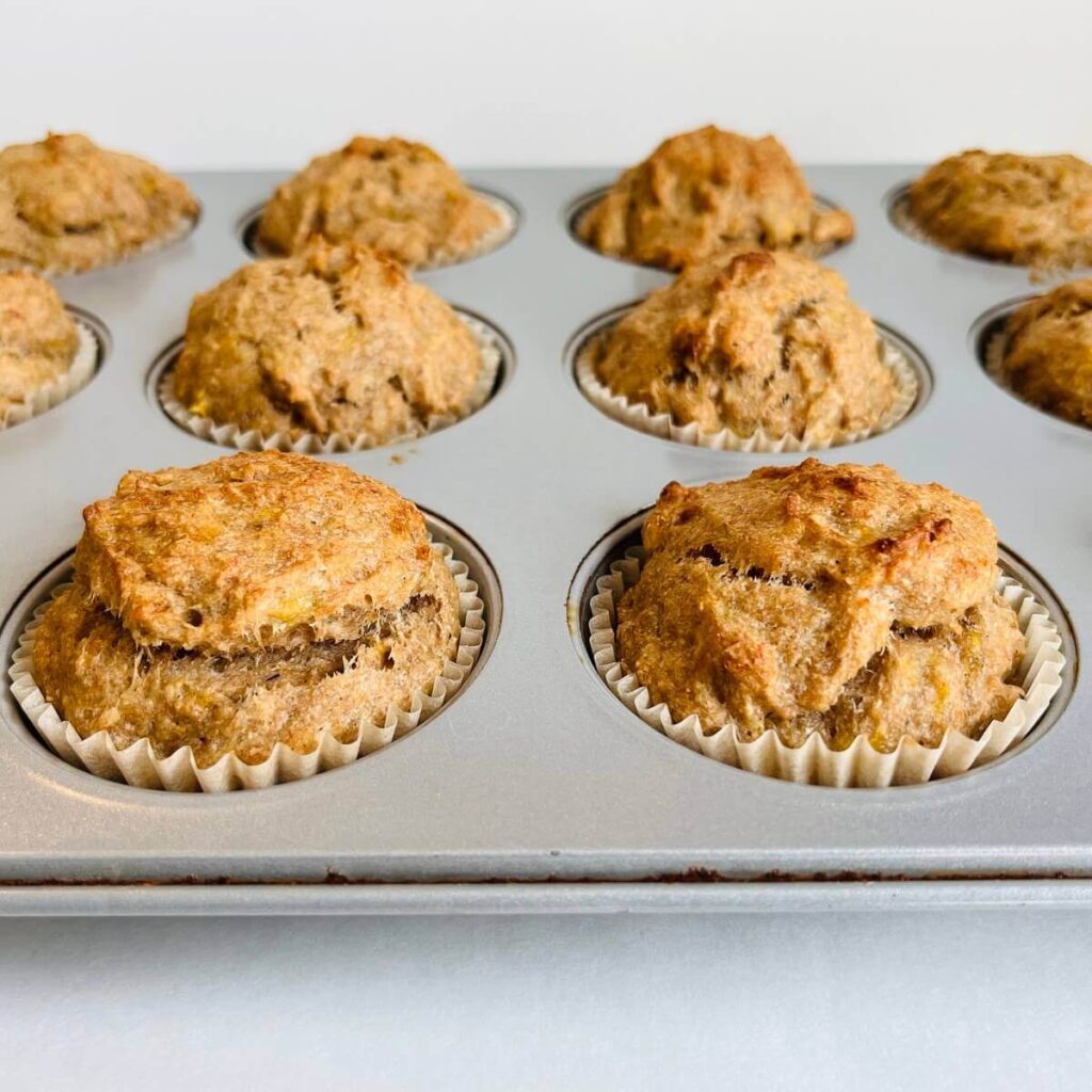 Baked maple banana muffins sitting in a muffin tin